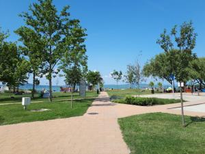 a walkway in a park with trees and the beach at Nyaralóház HANGA in Fonyód
