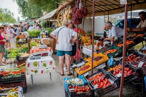 a group of people at a farmers market with fruits and vegetables at Nyaralóház HANGA in Fonyód