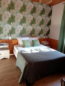 1 dormitorio con 1 cama con una pared cubierta de plantas en L'Auberge de Lugos, en Lugos