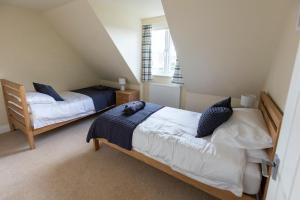 a bedroom with two beds in a attic at Luxury 5 bedroom house - sleeps 10 in Colkirk