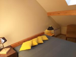 BertogneにあるGîte l'Ecole de ma Mèreのベッドルーム1室(黄色い枕のベッド1台付)