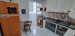 eine Küche mit einem Kühlschrank und einem Stuhl darin in der Unterkunft Ap Vista do mar - Praia das Pitangueiras in Guarujá