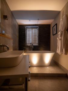 a large bathroom with a tub and a window at Padstow Escapes - The Long Room Luxury Apartment in Padstow