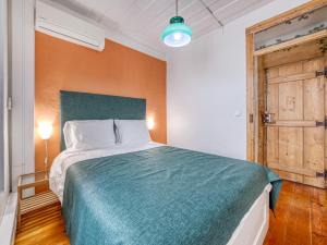 a bedroom with a large bed with a blue blanket at Apartment in the heart of Lisbon in Lisbon