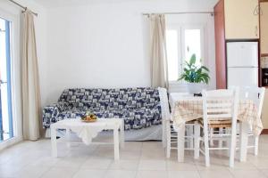 a living room with a couch and a table and chairs at Corali Hotel in Piso Livadi