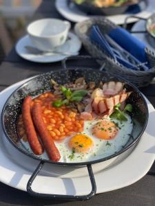 a plate of food with eggs and beans and bacon at Yacht Club Residence Sopot in Sopot