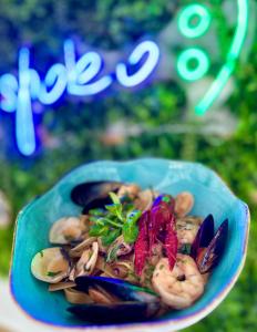 a blue bowl of food with mussels and other ingredients at Yacht Club Residence Sopot in Sopot