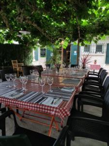 una mesa larga con copas de vino. en L'Auberge de Lugos en Lugos