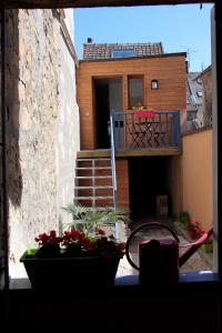 uma casa com varanda e flores numa janela em Loc'apparts em Beaumont-sur-Oise