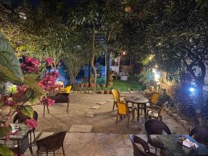 a patio with tables and chairs and trees at night at Birds Nest Hostel in Kathmandu