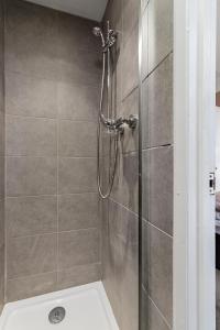 y baño con ducha y pared de azulejos. en Sunnymead en Torquay