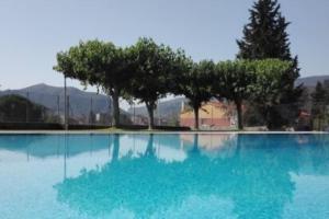 a large swimming pool with trees and blue water at agradable casa rural con chimenea y aire acondicionado in Vilavert