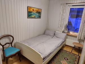 - un petit lit dans une chambre avec une chaise et une fenêtre dans l'établissement Apartament Sandstrand, 