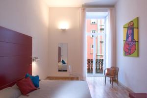 a bedroom with a bed and a room with a window at Hotel Piazza Bellini & Apartments in Naples