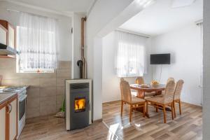 a kitchen and dining room with a table and a fireplace at Apartman Vedro Polje in Gospić