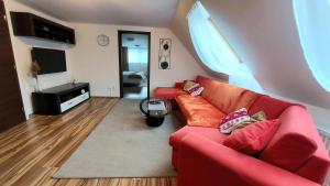 a living room with a red couch and a television at Apartmán Tajov pre 5-6 osôb, privatne parkovanie a terasa in Tajov