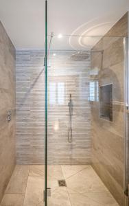 a shower with a glass door in a bathroom at Padstow Escapes - The Long Room Luxury Apartment in Padstow
