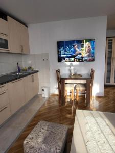 a kitchen with a table and a tv on the wall at OPTIMUM 2 - One bedroom apartment in Zenica