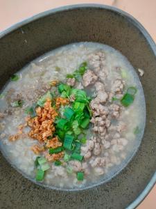 un tazón de sopa con camarones y cebollas verdes en Blue Moon House - A budget hostel for easy travellers, en Chiang Mai