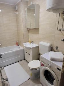 a bathroom with a toilet sink and a washing machine at OPTIMUM 2 - One bedroom apartment in Zenica