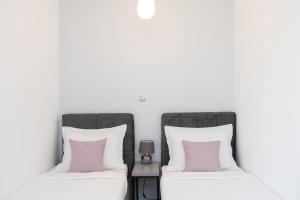 two beds sitting next to each other with pink pillows at Apartment Maris in Šibenik