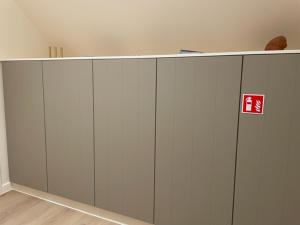a large white cabinet with a red sign on it at Velogement 't Moltje in Heuvelland