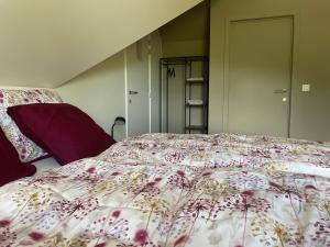 a bedroom with a bed with a floral bedspread at Velogement 't Moltje in Heuvelland