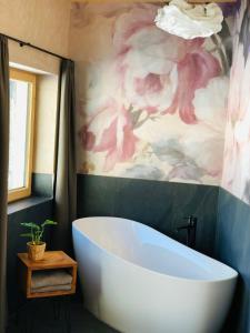 a bath tub in a bathroom with a painting of flowers at Löberbauer, Ferienwohnung in Tux
