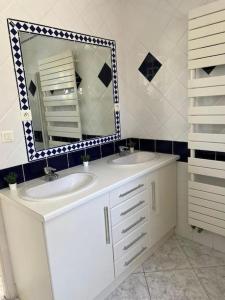 een badkamer met 2 wastafels en een spiegel bij Maison avec piscine privée in Le Grau-du-Roi