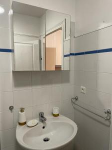 uma casa de banho branca com um lavatório e um espelho em Studio Centre Ville em Nice
