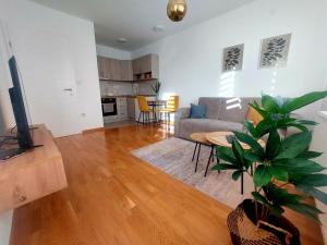 a living room with a couch and a potted plant at Apartman La Valletta, Doboj in Doboj