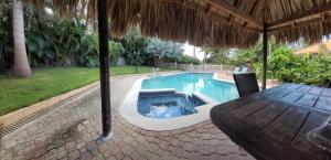 a swimming pool with a hot tub in a backyard at Villa Marie in Willemstad