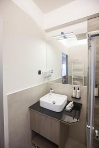 a bathroom with a sink and a mirror at AKROTHEA suites & lounge in Tripolis