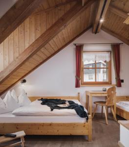 een slaapkamer met een bed en een bureau bij Chalet Winklwiese in Valdaora