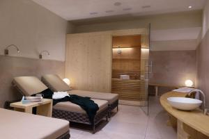 een badkamer met een bed en een wastafel in een kamer bij Chalet Winklwiese in Valdaora