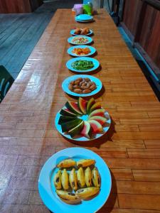 une longue table avec des assiettes de nourriture dans l'établissement Lalosi Homestay, à Besir