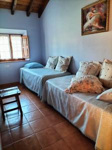 a room with two beds and a table in it at La Plaza de La Franca in La Franca