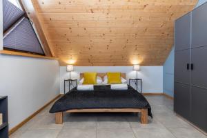 1 dormitorio con 1 cama grande con almohadas amarillas en APARTAMENT No 1 MOUNTAIN VIEV Sauna Priv okolice Zakopane Czorsztyn Kluszkowce en Kluszkowce
