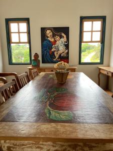ein Esszimmer mit einem Tisch und einem Gemälde darauf in der Unterkunft Pousada Artes Evano in Bichinho