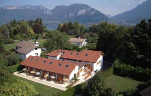 une vue aérienne sur une maison avec des montagnes en arrière-plan dans l'établissement L'Aurore du Lac, à Sévrier