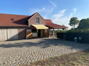 une maison en briques avec un garage et une allée dans l'établissement Velogement 't Moltje, à Heuvelland