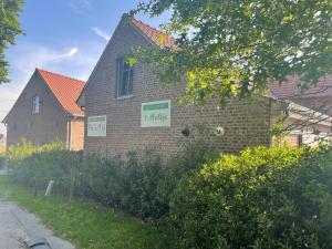 a brick house with a sign that says i hate at Velogement 't Moltje in Heuvelland