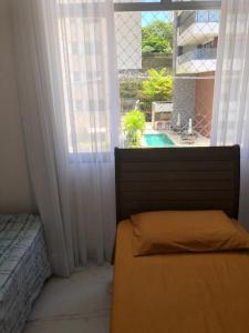 1 dormitorio con cama y ventana con vistas en Feriado em Salvador!, en Salvador