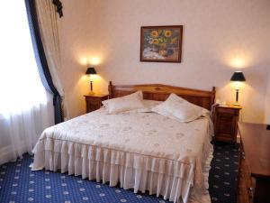 a bedroom with a large bed with two night stands at Grand Hotel Ukraine in Dnipro