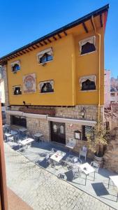a building with tables and chairs in front of it at Apartamento en Navacerrada in Navacerrada