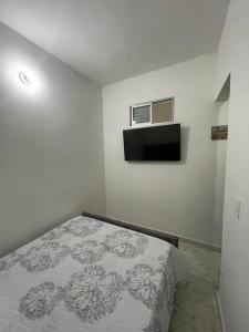 Dormitorio blanco con cama con manta en Aparta-hotel laureles 201, en Medellín