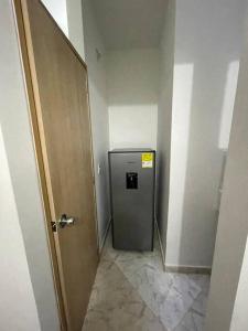 einen Flur mit kleinem Kühlschrank in einem Zimmer in der Unterkunft Aparta-hotel laureles 201 in Medellín