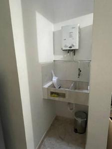 baño con lavabo y dispensador de jabón en Aparta-hotel laureles 201, en Medellín