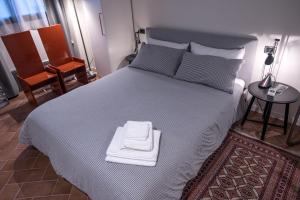 1 dormitorio con 1 cama grande y 2 toallas. en B&B Maria Teresa, en Cremona