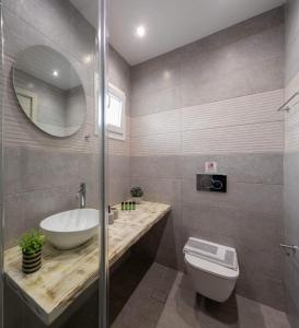 a bathroom with a sink and a toilet and a mirror at HELIAIA in Naxos Chora